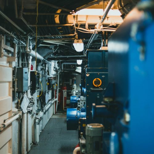 pexels-photo-10290629-10290629 A detailed view of industrial machinery and pipes in a maintenance corridor.